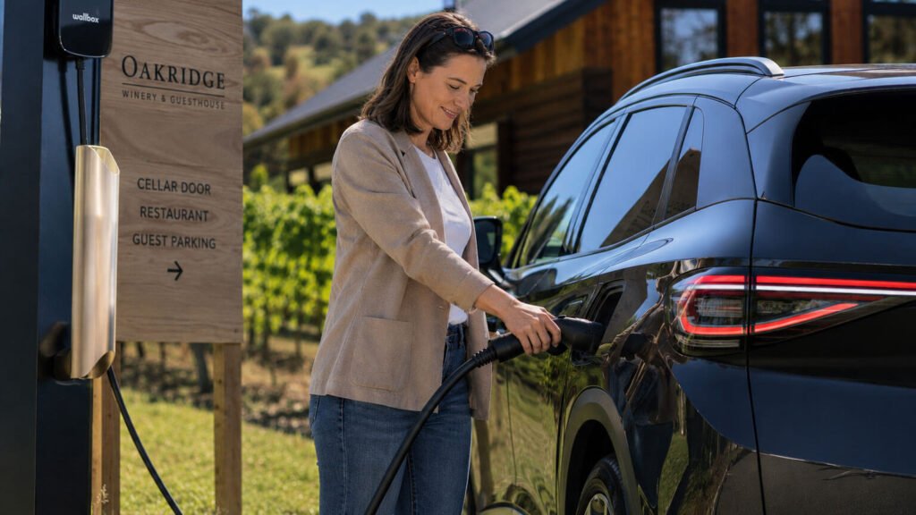 Woman charging her EV vehicle outside a winery