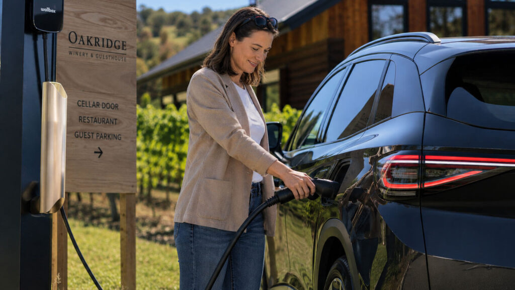 Woman charging her EV vehicle outside a winery